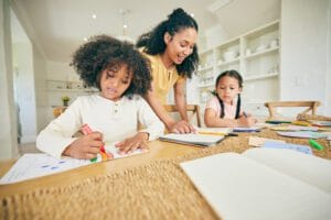 Mother teaching kindergarten reading and phonics activities with children at home